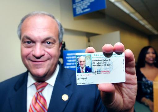 New Haven Mayor John DeStefano Jr., shows his new Elm City Resident Card at New Haven City Hall. Photo source: Arnold Gold/New Haven Register, http://nhregister.com/articles/2012/07/24/news/new_haven/doc500f494fc0246793991800.txt